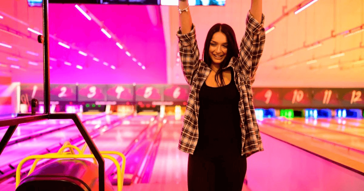 girl celebrating a strike at tenpin bowling